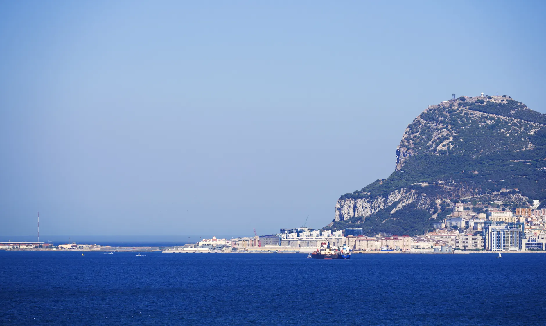 Scenic view of the iconic Rock of Gibraltar, with clear blue sky and sea, ideal for travel imagery.